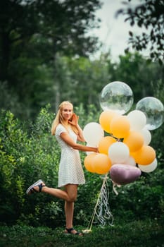 young girl with balloons on nature background.