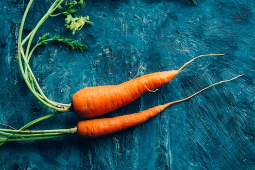 Fresh carrots on a blue wooden background.