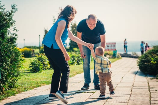 Happy family with baby son on nature background.