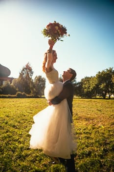 Dancing young bride and groom sunlight background.