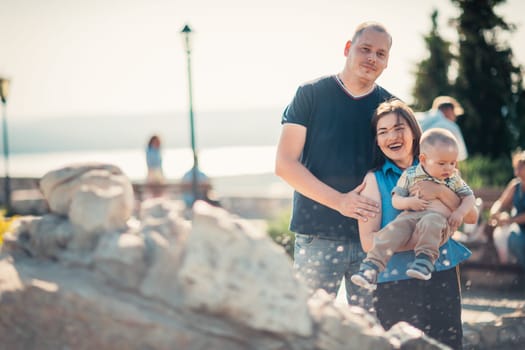Happy family with baby near the fountain.