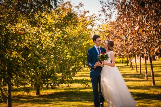 Beautiful stylish bride and groom on garden background.