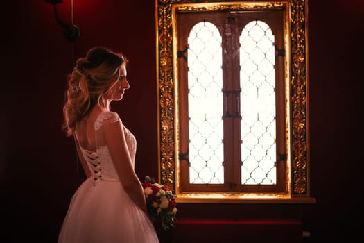 Portrait young beauty bride near the window.