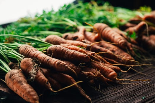 Fresh carrots close-up on a wooden background.