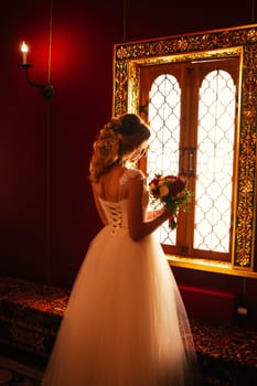 Portrait young beauty bride near the window.