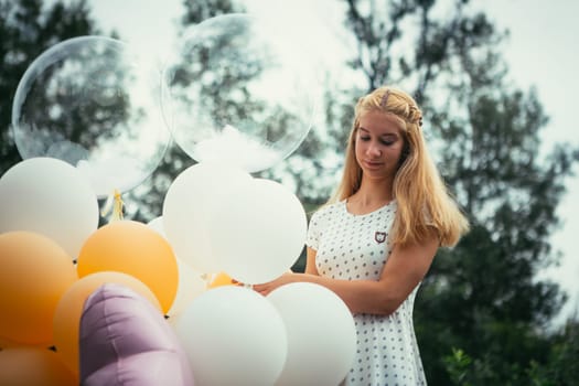 young girl with balloons on nature background.