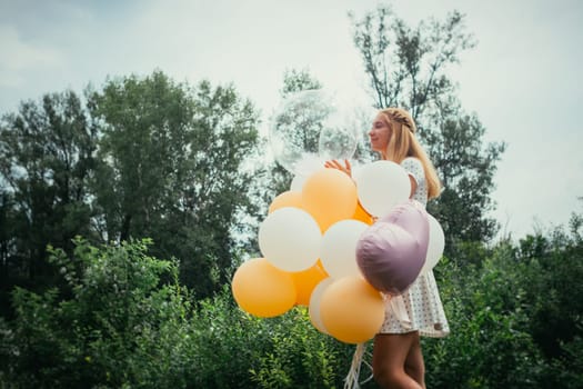 young girl with balloons on nature background.