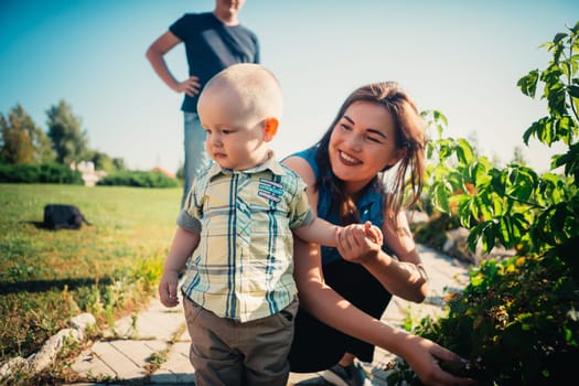 Happy family with baby son on nature background.