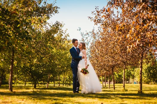 Beautiful stylish bride and groom on garden background.