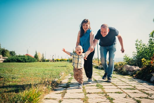 Happy family with baby son on nature background.