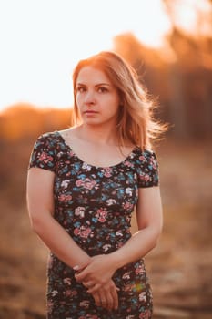 portrait of a beautiful girl in a field on a sunset background.