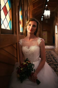 Portrait young beauty bride near the window.