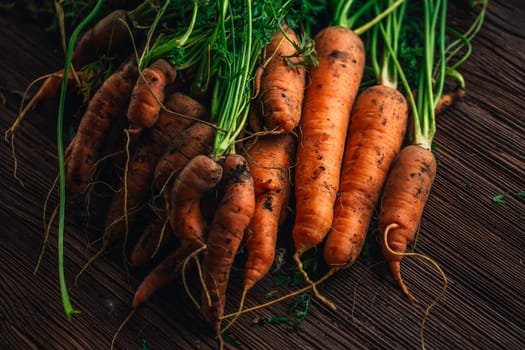 Fresh carrots from the garden close-up on a wooden background.