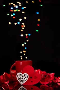 Still life: Cup of coffee, red heart and roses on black background with heart-shaped bokeh. Copy space. Valentine's Day setting table. Design element for romantic greeting card, festive menu of cafe