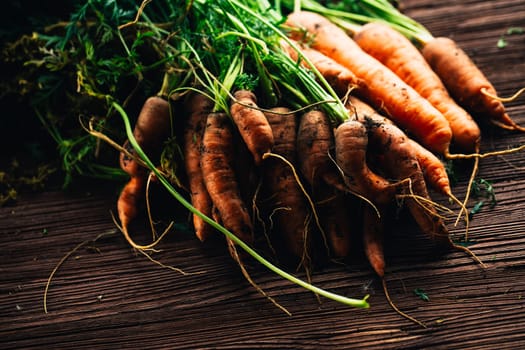Fresh carrots from the garden close-up on a wooden background.