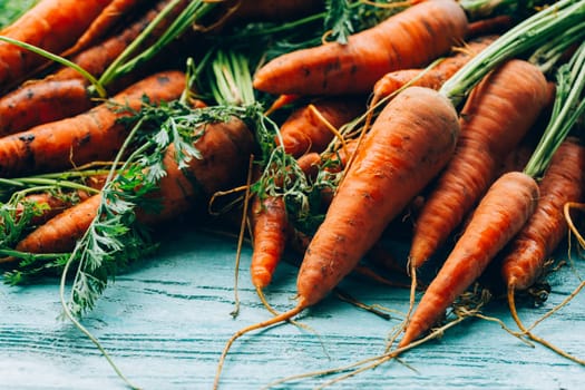 lot of carrots on a wooden background.