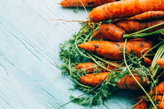 lot of carrots on a wooden background.
