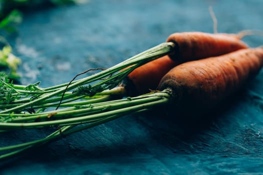 Fresh carrots on a blue wooden background.