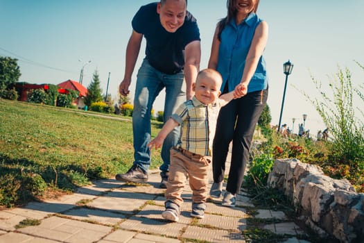 Happy family with baby son on nature background.
