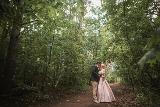 bride and groom dancing in the forest background and sunlight.