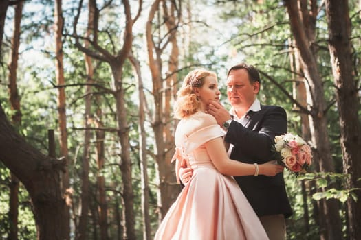 bride and groom on the background of trees and woods in full growth.