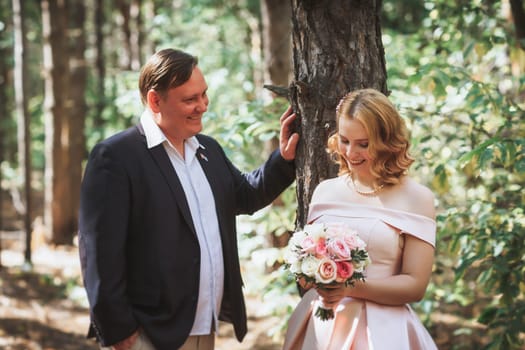 bride and groom kiss on the background of trees and forest.