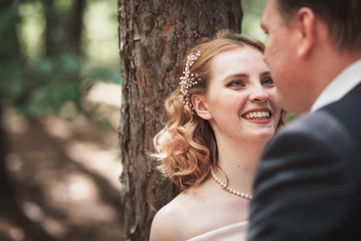 bride and groom on the background of trees and forest sun.