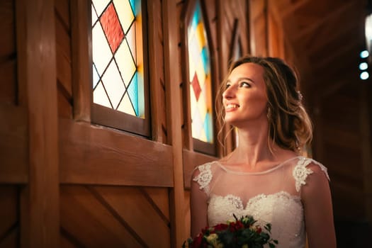 Portrait young beauty bride near the window.