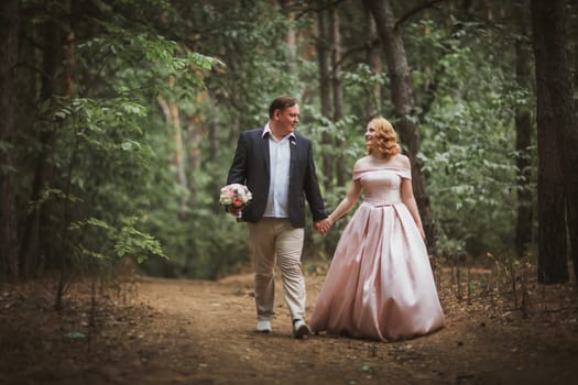 bride and groom kissing in the summer forest.