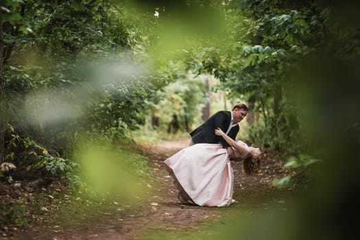 bride and groom dancing in the forest background and sunlight.