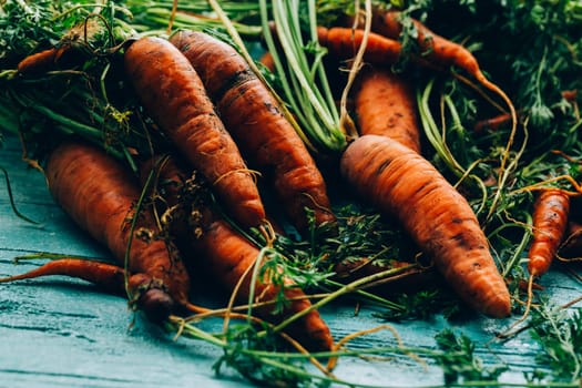 lot of carrots on a wooden background.
