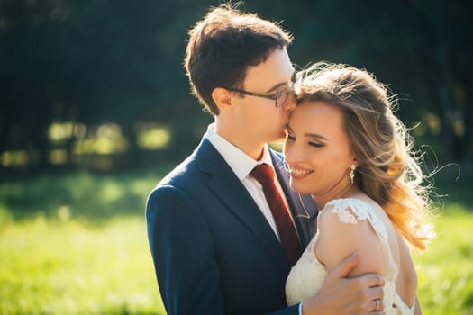 bride and groom embracing on nature background.