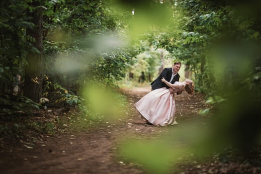 bride and groom dancing in the forest background and sunlight.