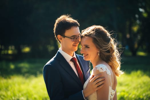 bride and groom embracing on nature background.