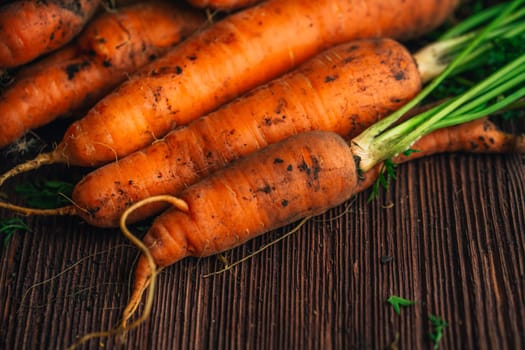 Fresh carrots close-up on a wooden background.