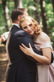 bride and groom on the background of trees and forest sun.