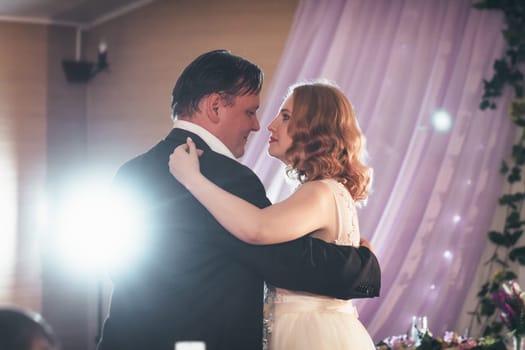 bride and groom first dancing on background a restaurant.