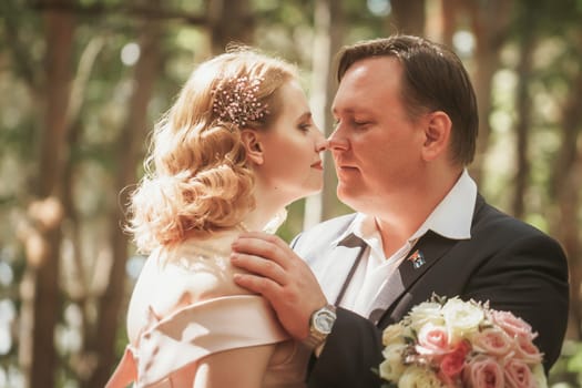 bride and groom kiss on the background of trees and forest.