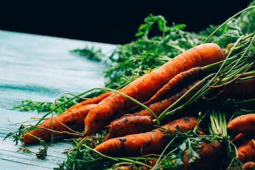 lot of carrots on a wooden background.