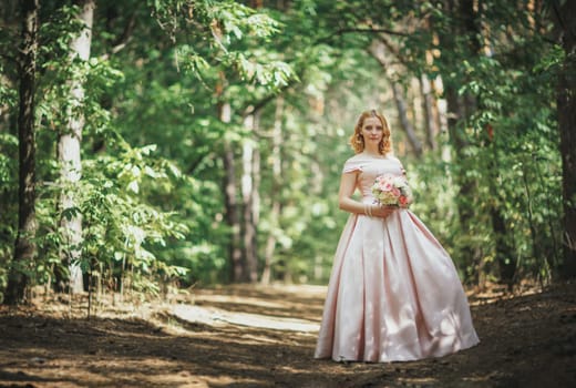 portrait of a beautiful bride standing near a tree.