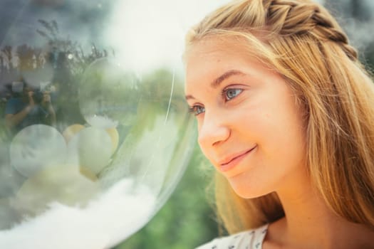 portrait of young girl with balloons on nature background.