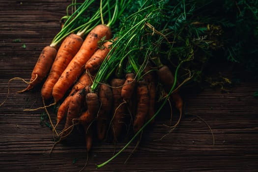 Fresh carrots from the garden close-up on a wooden background.