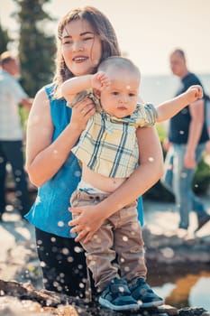 happy mother and toddler son near the fountain.