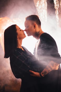 Couple in fashionable clothes on a shiny background.