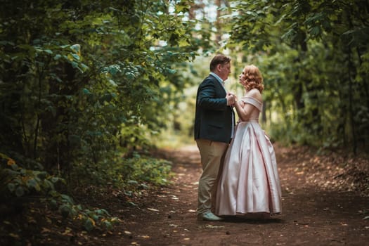 bride and groom dancing in the forest background and sunlight.