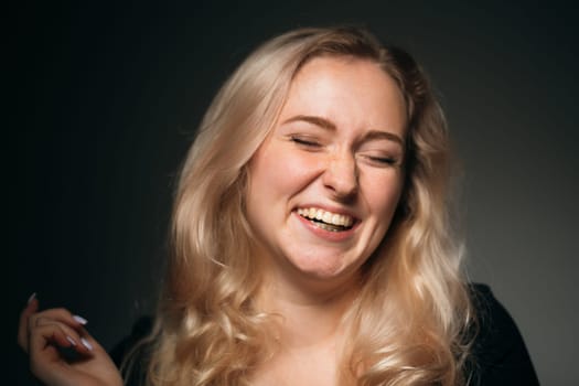young girl blonde on a dark background.