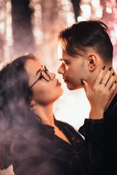 Couple in fashionable clothes on a shiny background.