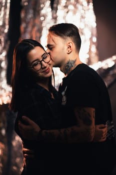 Couple in fashionable clothes on a shiny background.