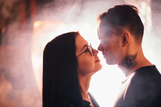 Couple in fashionable clothes on a shiny background.