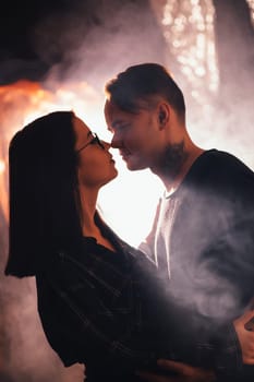 Couple in fashionable clothes on a shiny background.